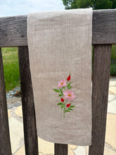Lade das Bild in den Galerie-Viewer, Geschirrtuch aus Reinleinen mit handgestickter Heckenrose – nachhaltiges Küchentuch, hängt über einer Stuhllehne
