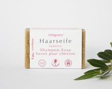 Lade das Bild in den Galerie-Viewer, Aufrecht stehende sensitive Haarseife von FINigrana mit weißer Umverpackung und rosa Schrift. Palmölfrei, kontrollierte Natur-Kosmetik BDIH und vegan. Davor liegt ein Olivenzweig. 

